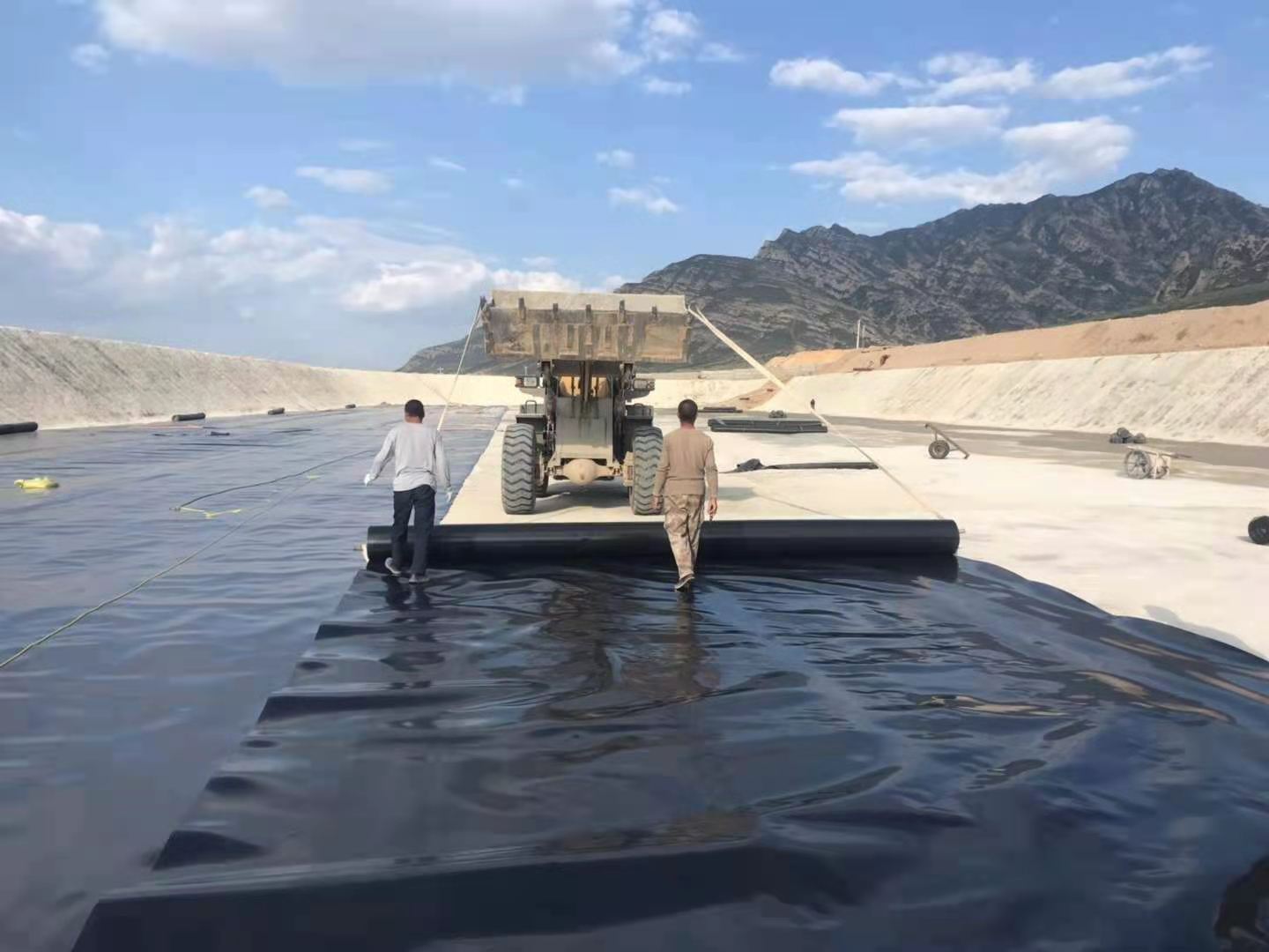 复合土工膜与基座和支撑层应压平贴合，避免架空，排除气泡，确保安全。